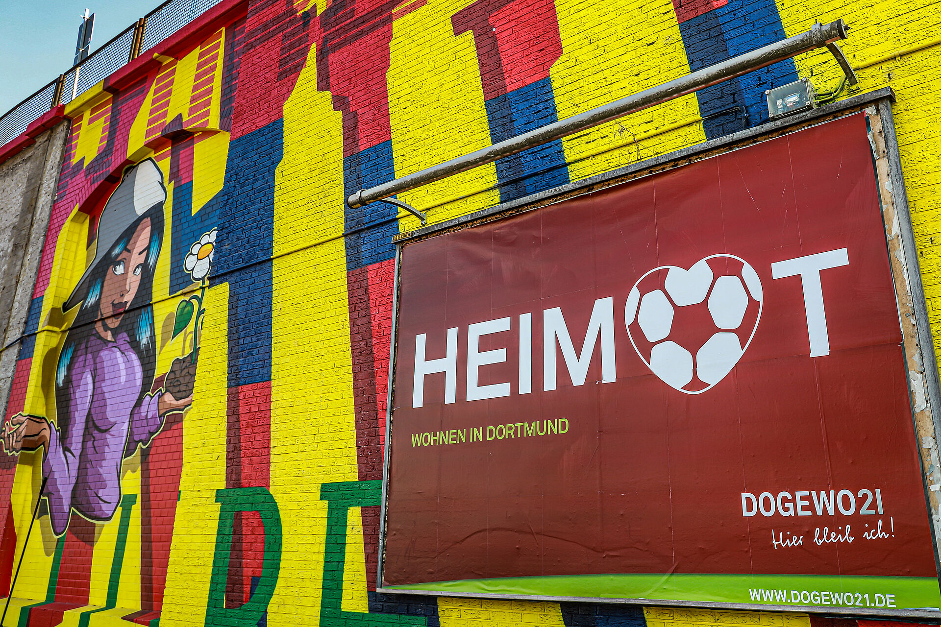 Bild einer Graffittiwand mit dem Banner "Heimat" von DOGEWO21