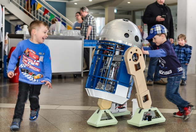 Kleine Kinder spielen mit einem R2D2-Nachbau