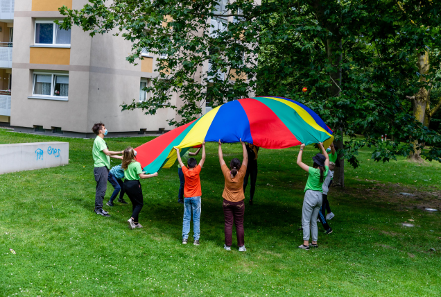 Kinder spielen mit einem bunten Schwungtuch