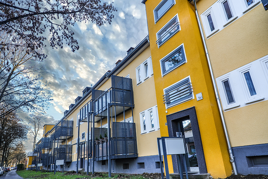 Frische Fassadenfarben und Dämmung Frisch gestrichenes, modernes Mehrfamilienhaus.