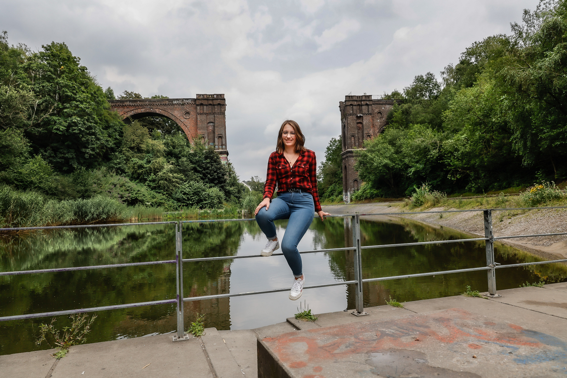 Ein Mädchen sitzt auf dem Geländer einer Brücke