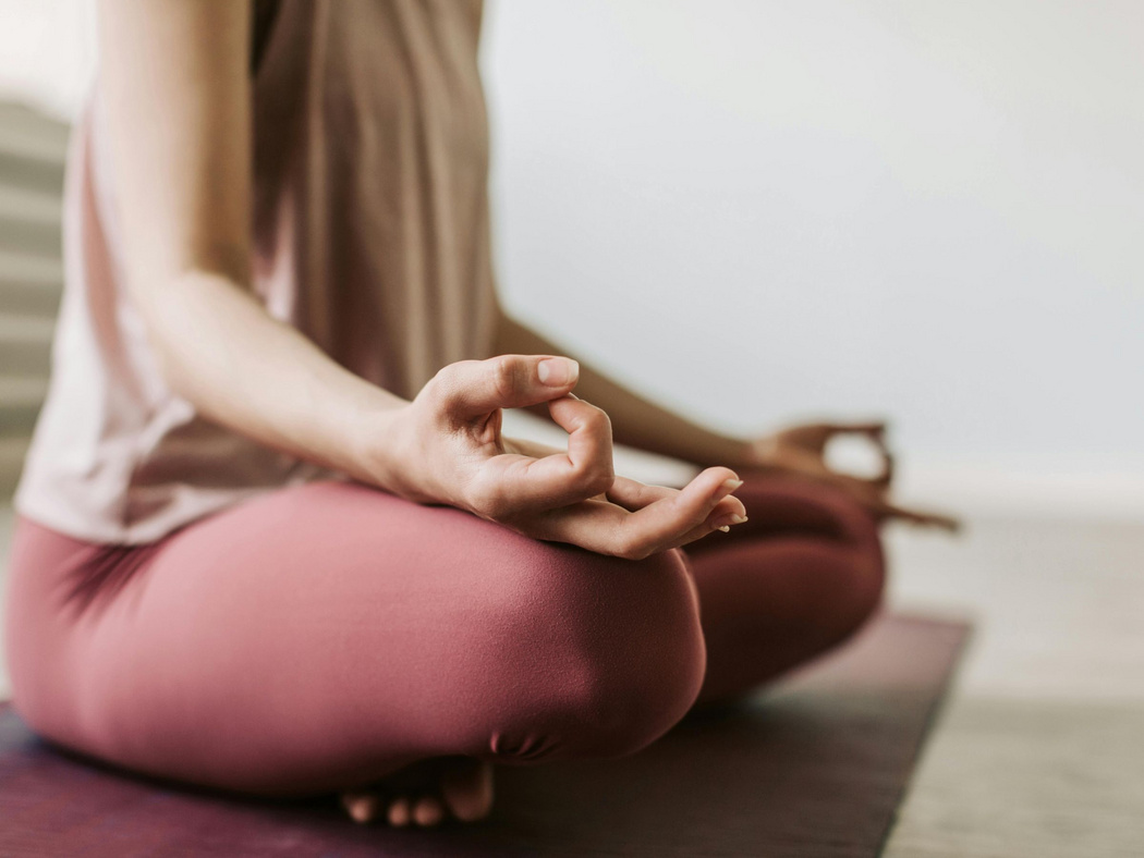 Eine Frau in Sportkleidung im Schneidersitz