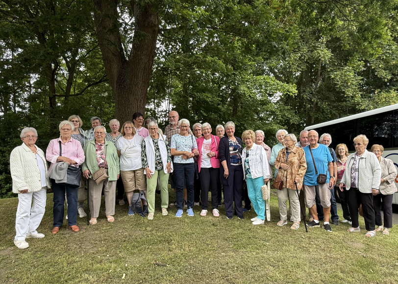 27 Frauen und Männer stehen im Kurpark Bad Sassendorf im Grünen.