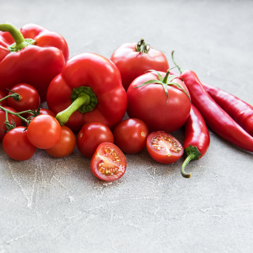 Rote Paprika, Kirschtomaten und Chili liegen auf einer Arbeitsplatte