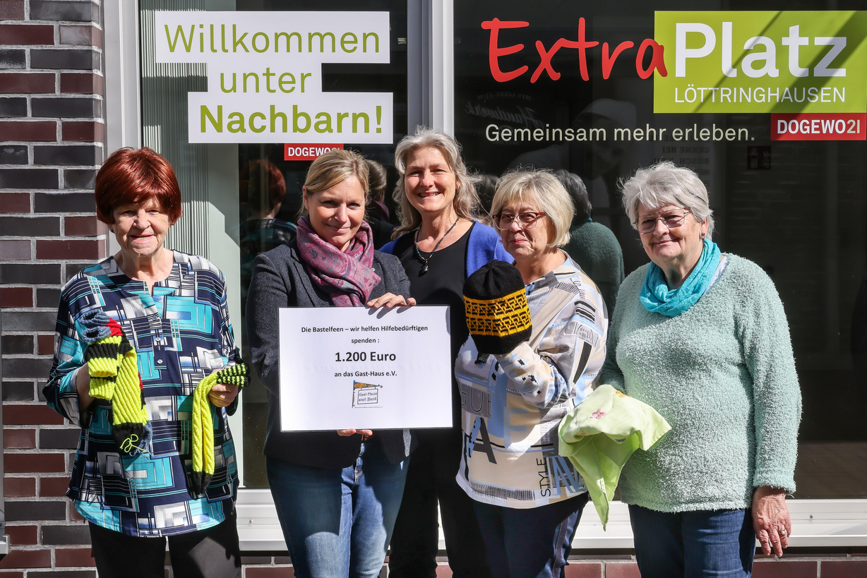 Fünf Frauen stehen vor dem Schaufenster des Nachbarschaftstreffs und lächeln in die Kamera.