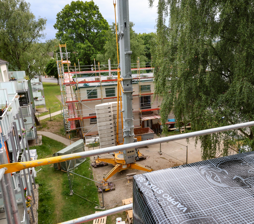 Bild von einer Dachgeschoss-Aufstockung. Blick vom Baugerüst auf die Baustelle.