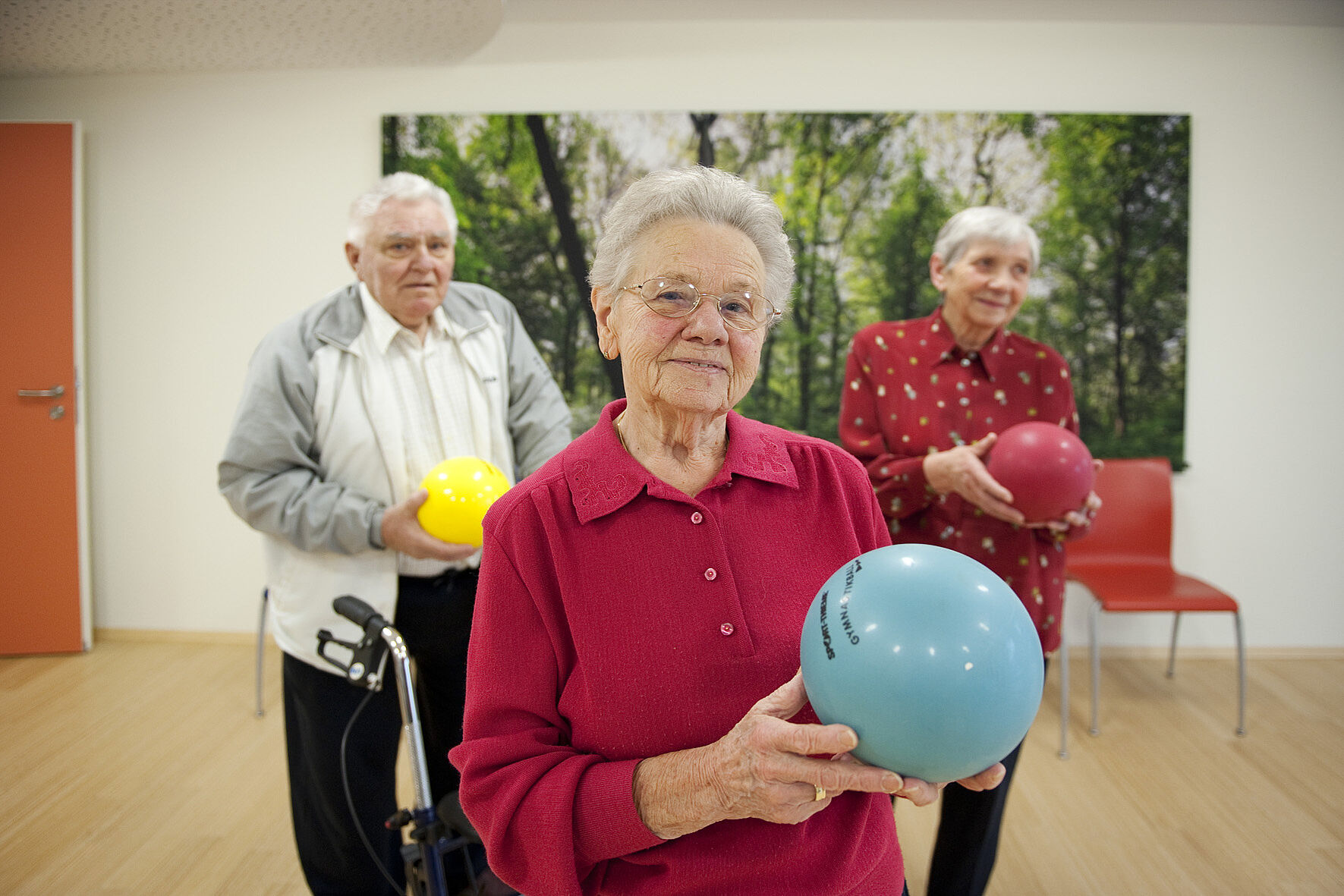 Zwei ältere Damen und ein Herr beim Spielen mit einem Ball