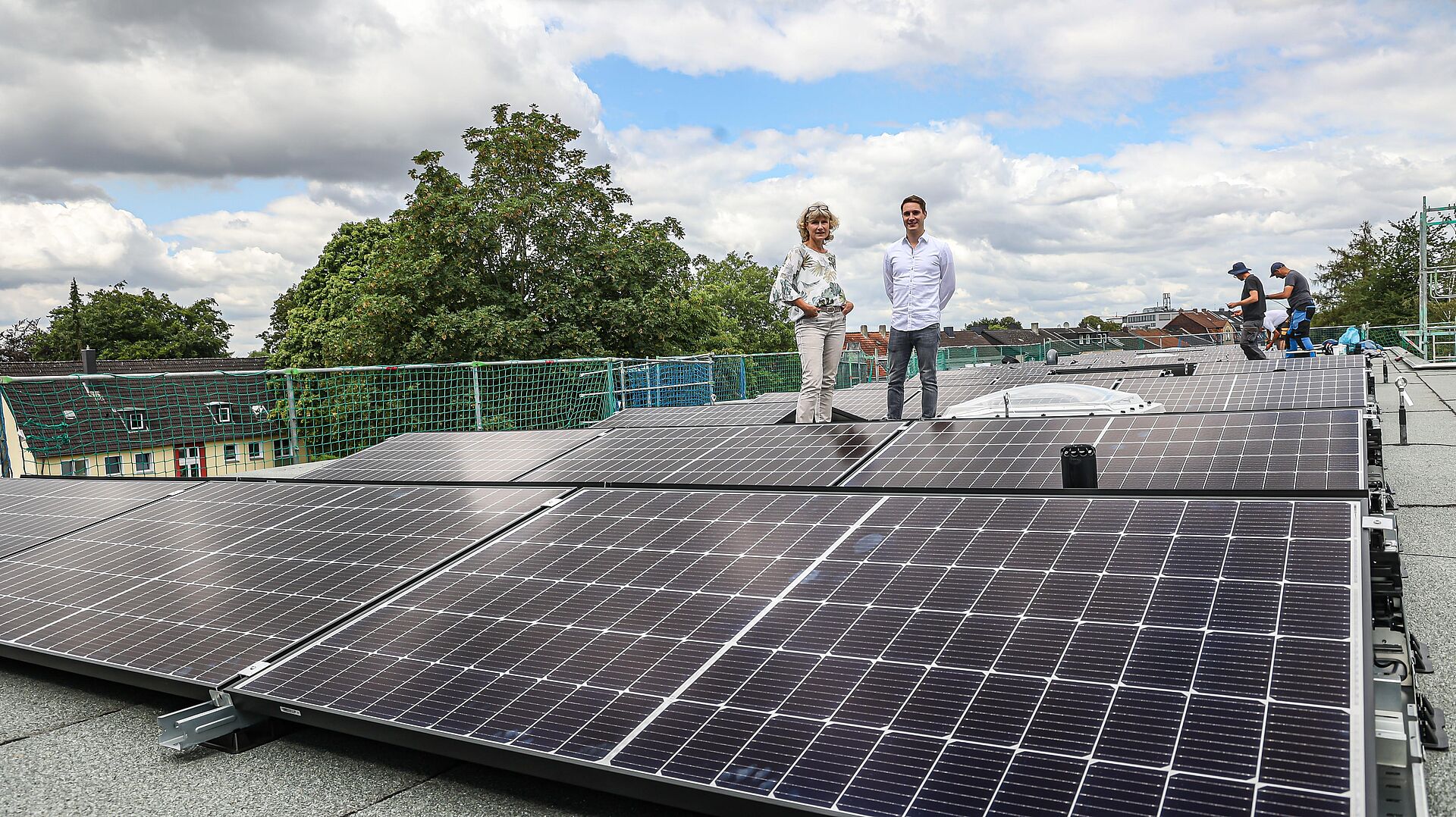 Photovoltaikanlage auf dem flachen Pultdach von drei Mehrfamilienhäusern produziert Solarstrom