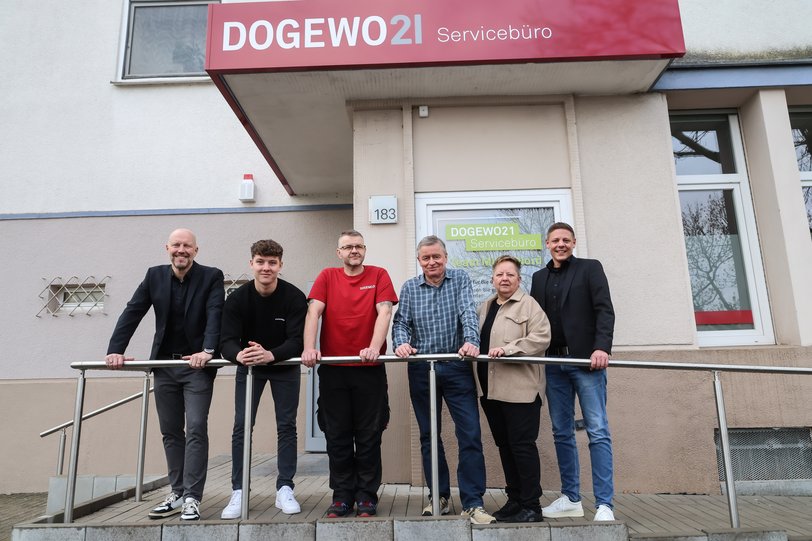 Mitarbeiter und Mitarbeiterin von DOGEWO21 stehen vor dem neuen Servicebüro