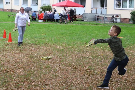 Kind und Frau spielen im Garten Tennis