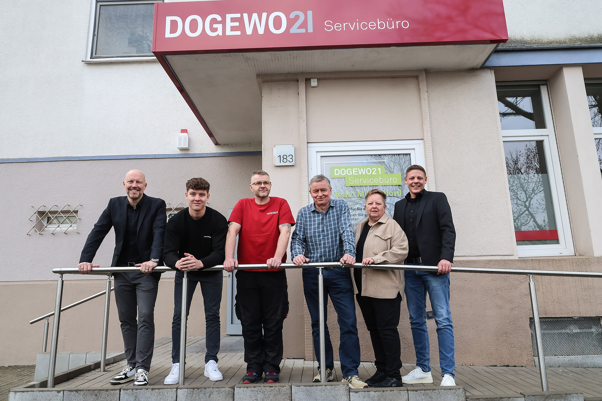 Mitarbeiter und Mitarbeiterin von DOGEWO21 stehen vor dem neuen Servicebüro