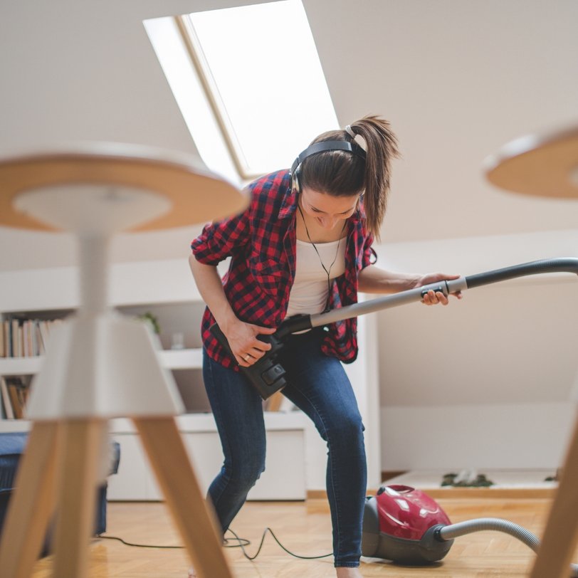 Frau spielt Gitarre mit einem Staubsauger