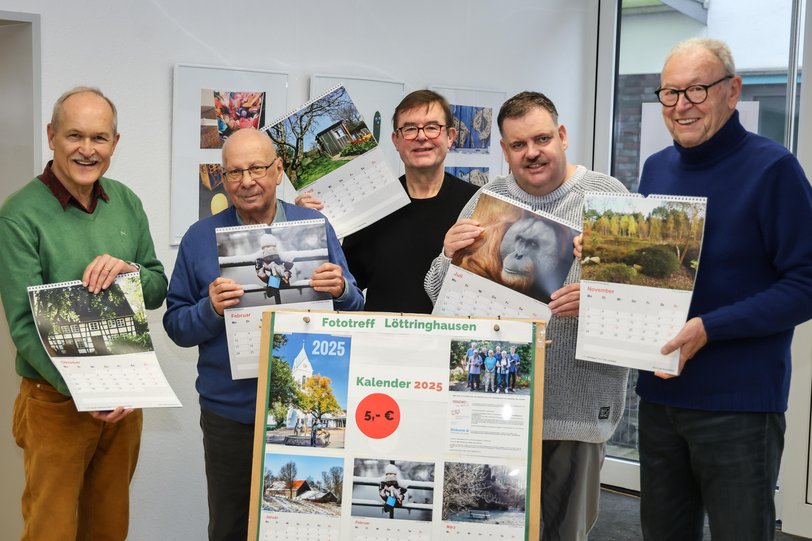Fünf Männer präsentieren die Fotomotive ihres neuen Kalenders in einem Nachbarschaftstreffpunkt von DOGEWO21.