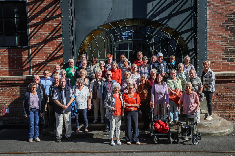 Etwa 50 Frauen und Männer stehen auf den Stufen des Eingangs der Zeche Zollern, um ein gemeinsames Gruppenfoto aufzunehmen.
