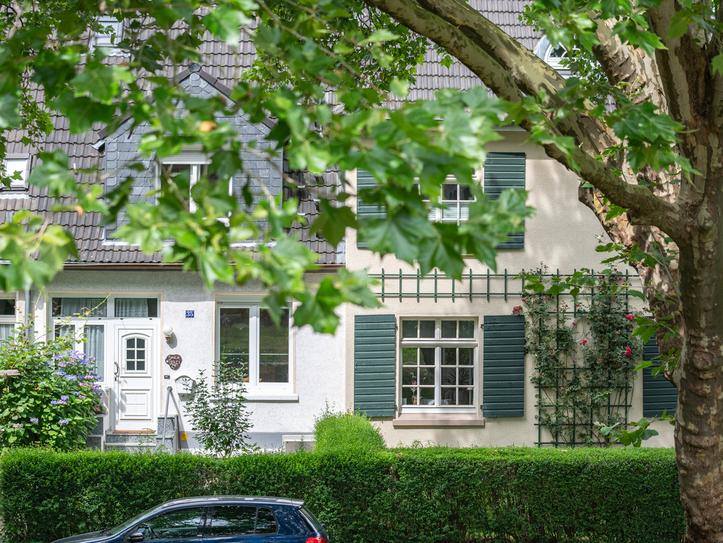 Eine Hausfront mit einem Baum im Vordergrund