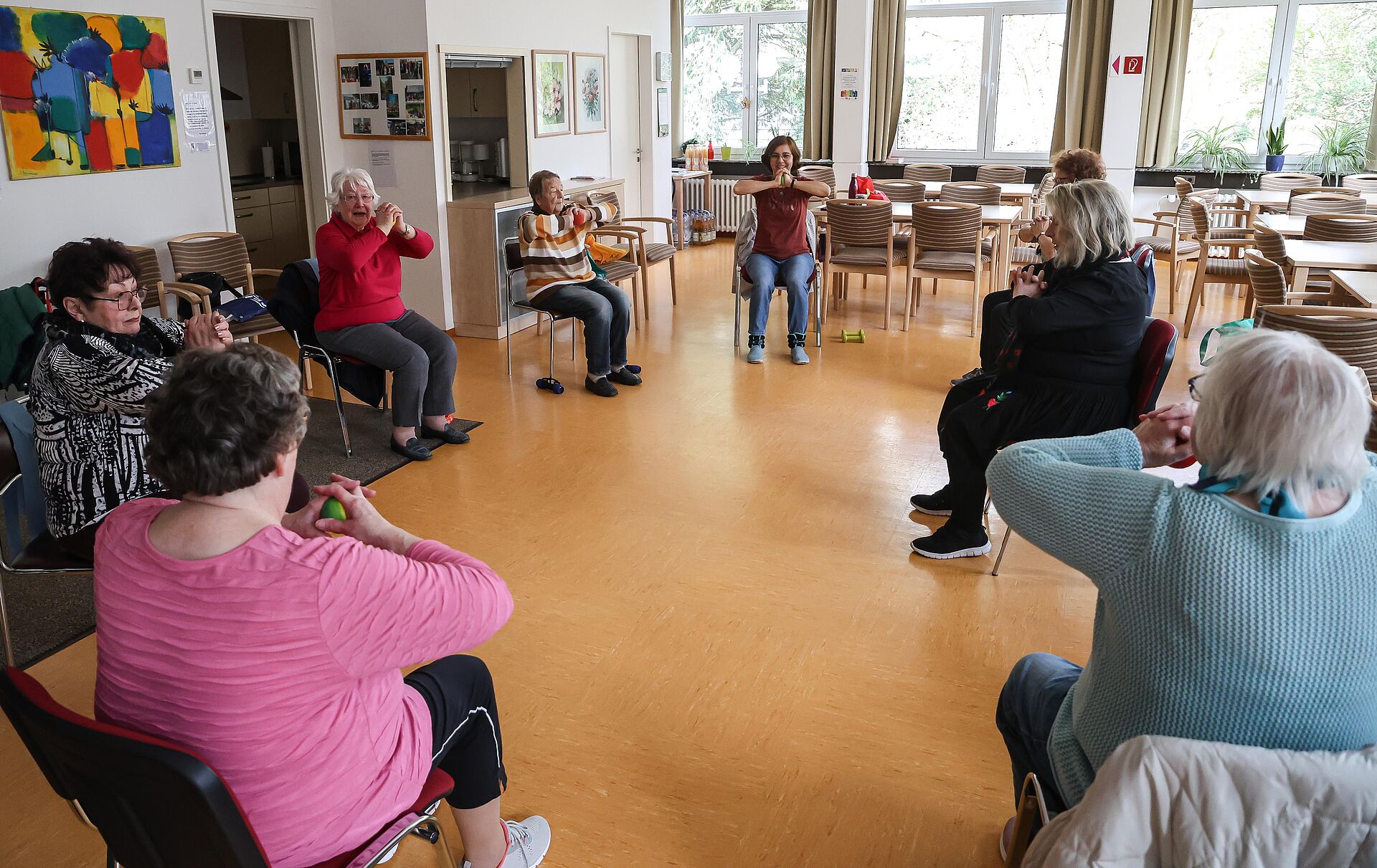 Seniorinnen machen Gymnastik im Sitzen