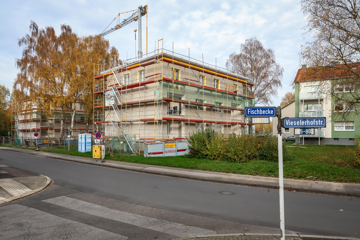 Im Hintergrund ein Haus mit Baugerüst und im Vordergrund eine Starße