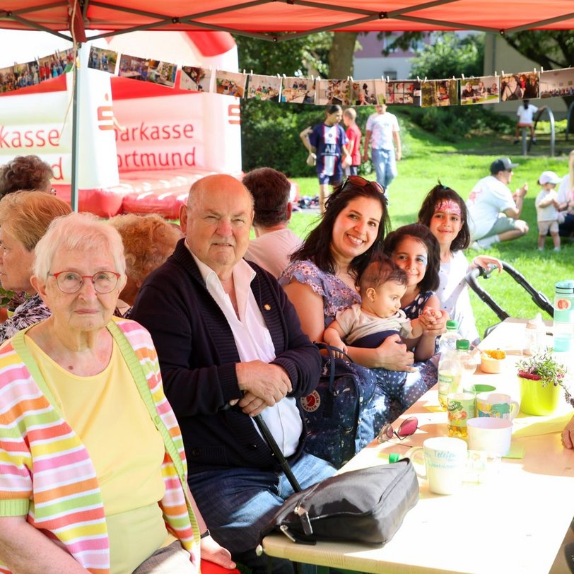Menschen bei einem Sommerfest auf einer Bierzeltgarnitur