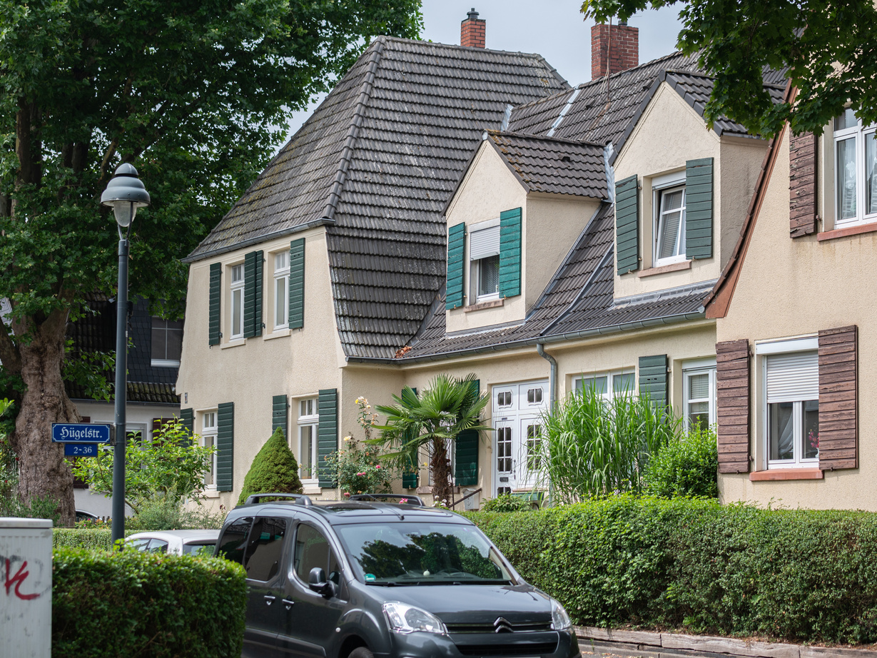 Eine Straße mit Häusern und einem im Vordergrund geparktem PKW