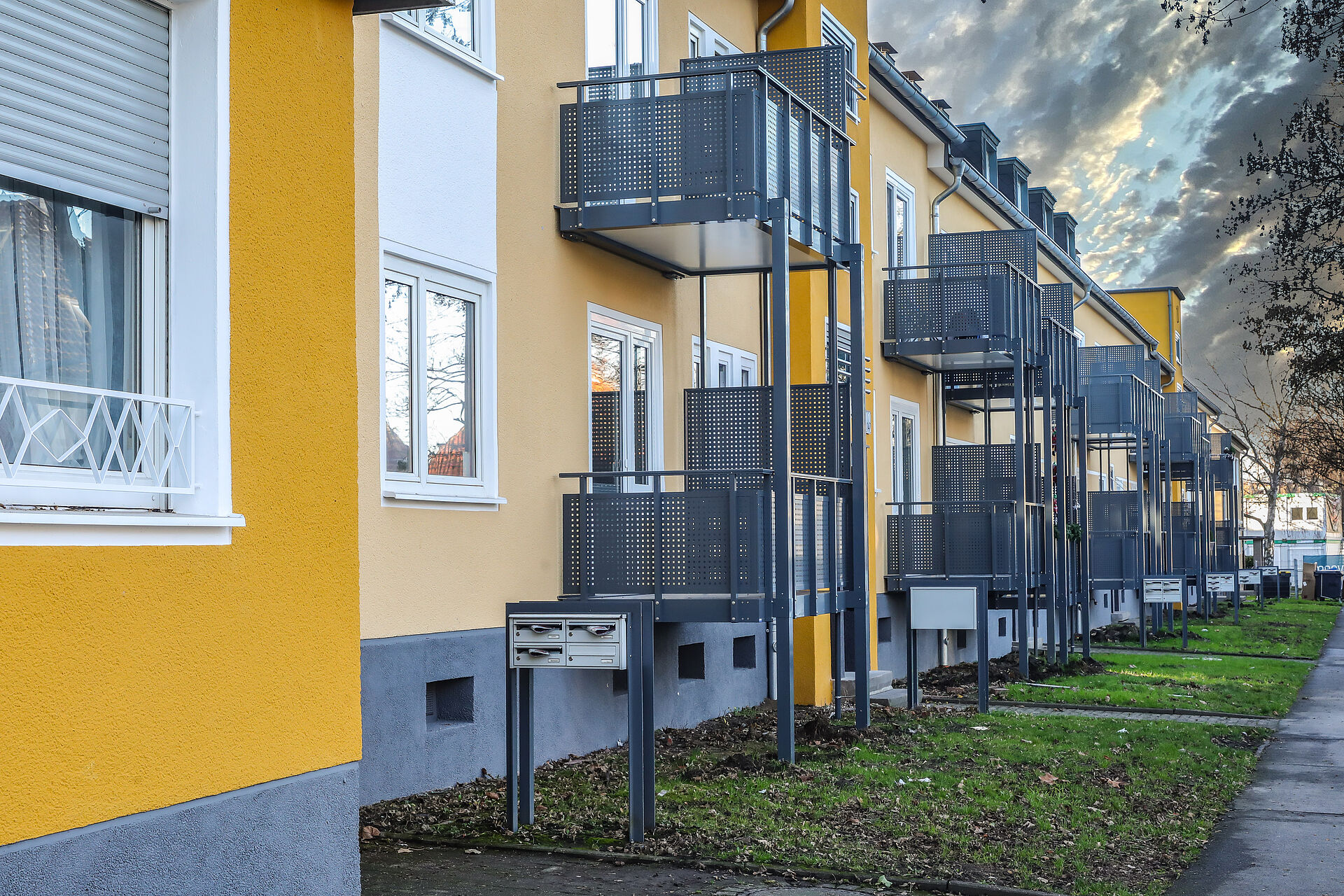 Frisch gestrichene gelbe Mehrfamilienhäuser mit neu angebauten Balkonen