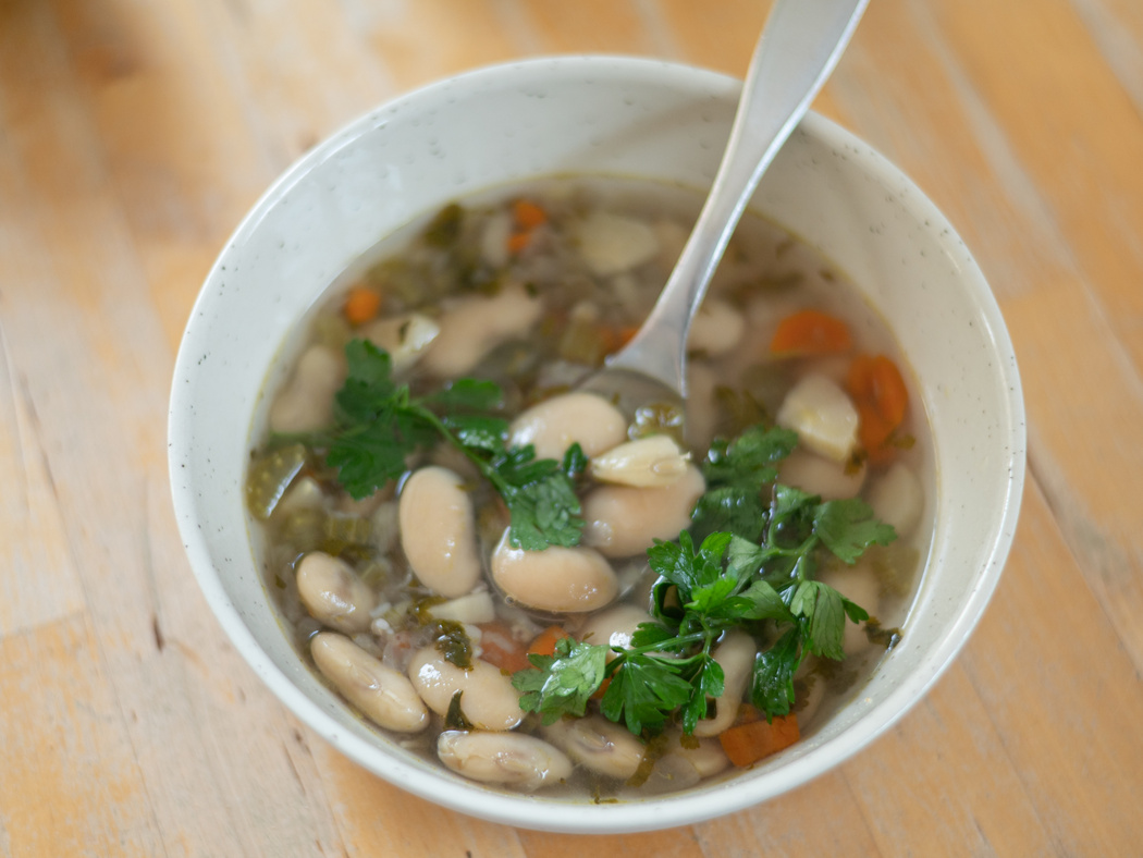 Ein Suppenteller mit Bohnensuppe auf einem Tisch.