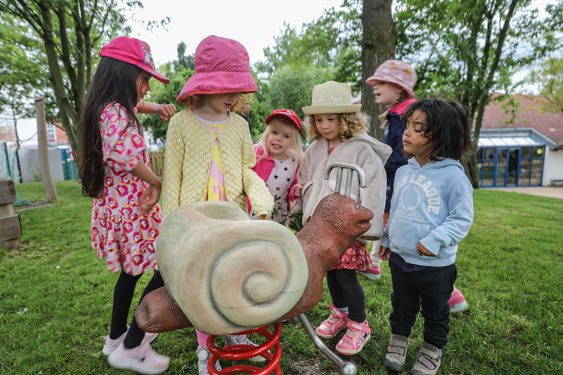 Kinder betrachten eine Schaukel-Schnecke 