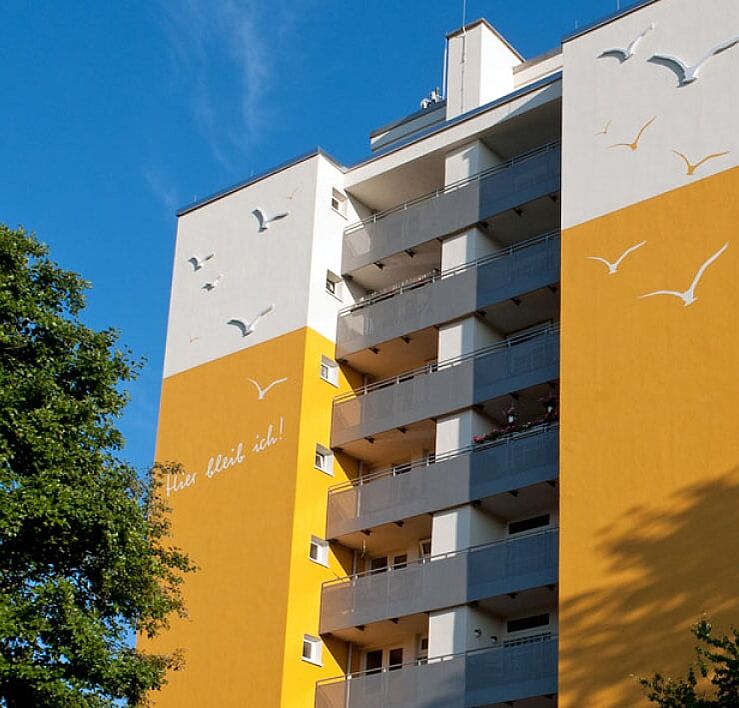 Gelb-weißes Hochhaus vor blauem Himmel