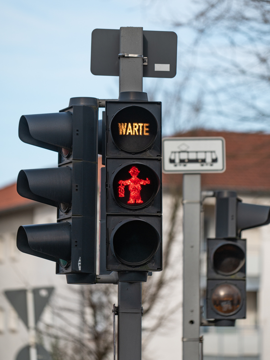 Eine Ampel mit einem roten Ampelmännchen, das eine Bergbau-Laterne in der Hand hält.