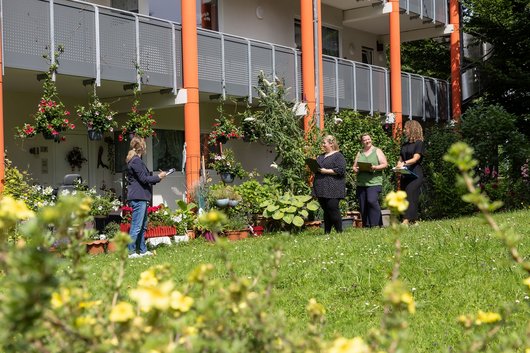 4 Frauen bewerten die Blumenpracht an den Balkonen.