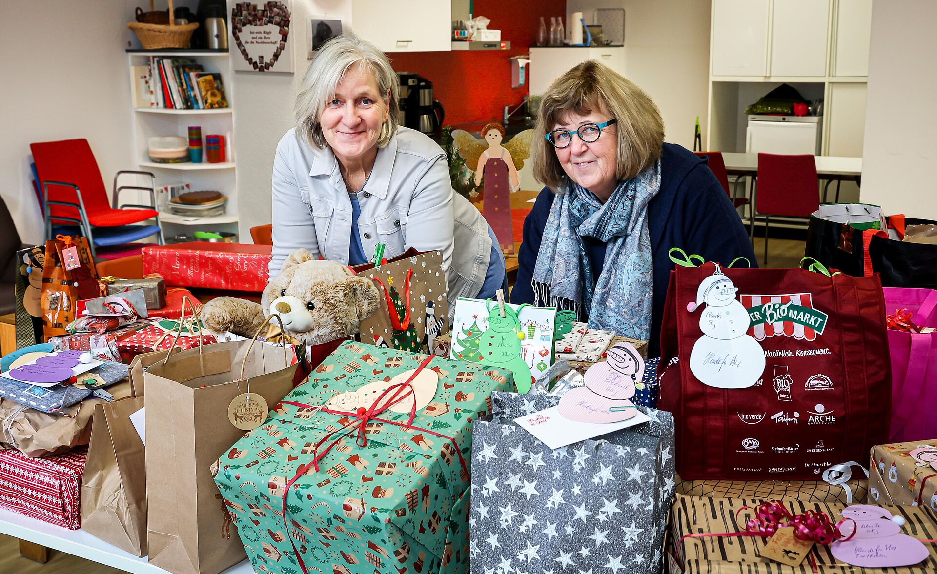 Zwei Frauen präsentieren einen Tisch voller Geschenke