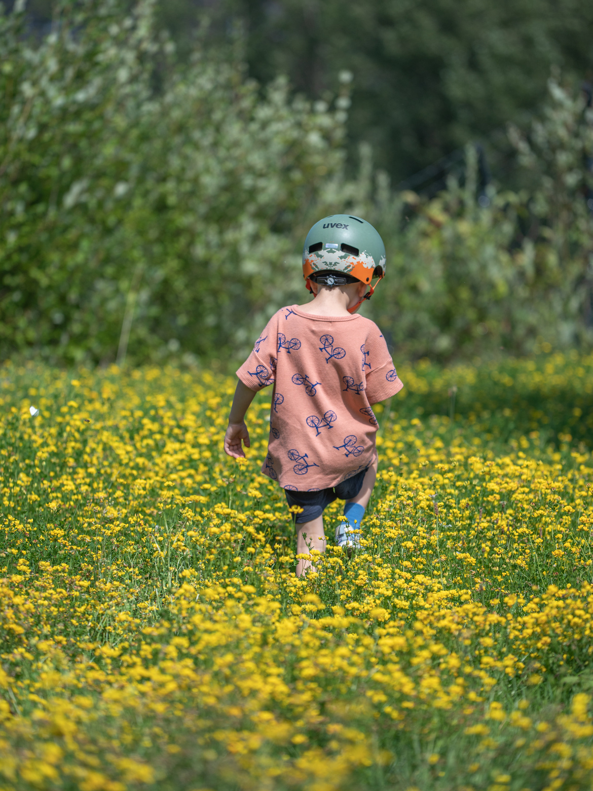 Ein Kind läuft durch eine gelbe Blumenwiese