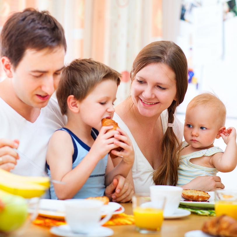 Familie beim Frühstück (Mutter, Vater, Kind und Baby)