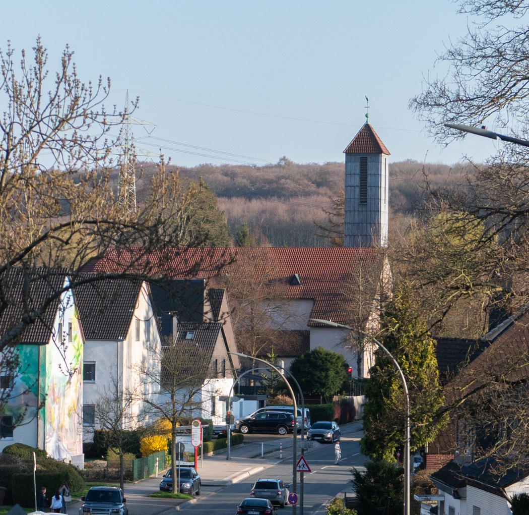 Blick entlang einer Straße mit Häusern und einer Kirche 
