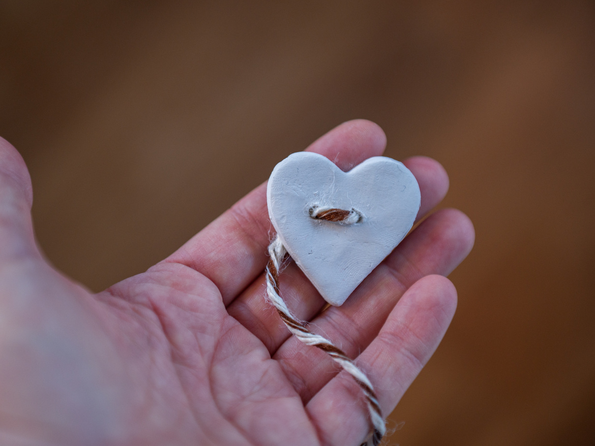 Ein Ton-Herz mit durchgezogener Kordel.