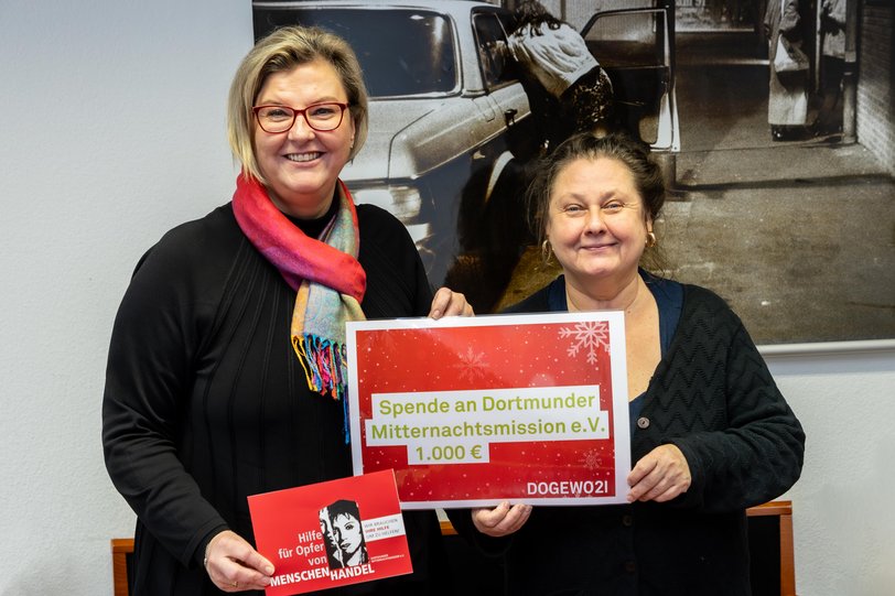 2 Frauen halten einen Spendenbetrag hoch