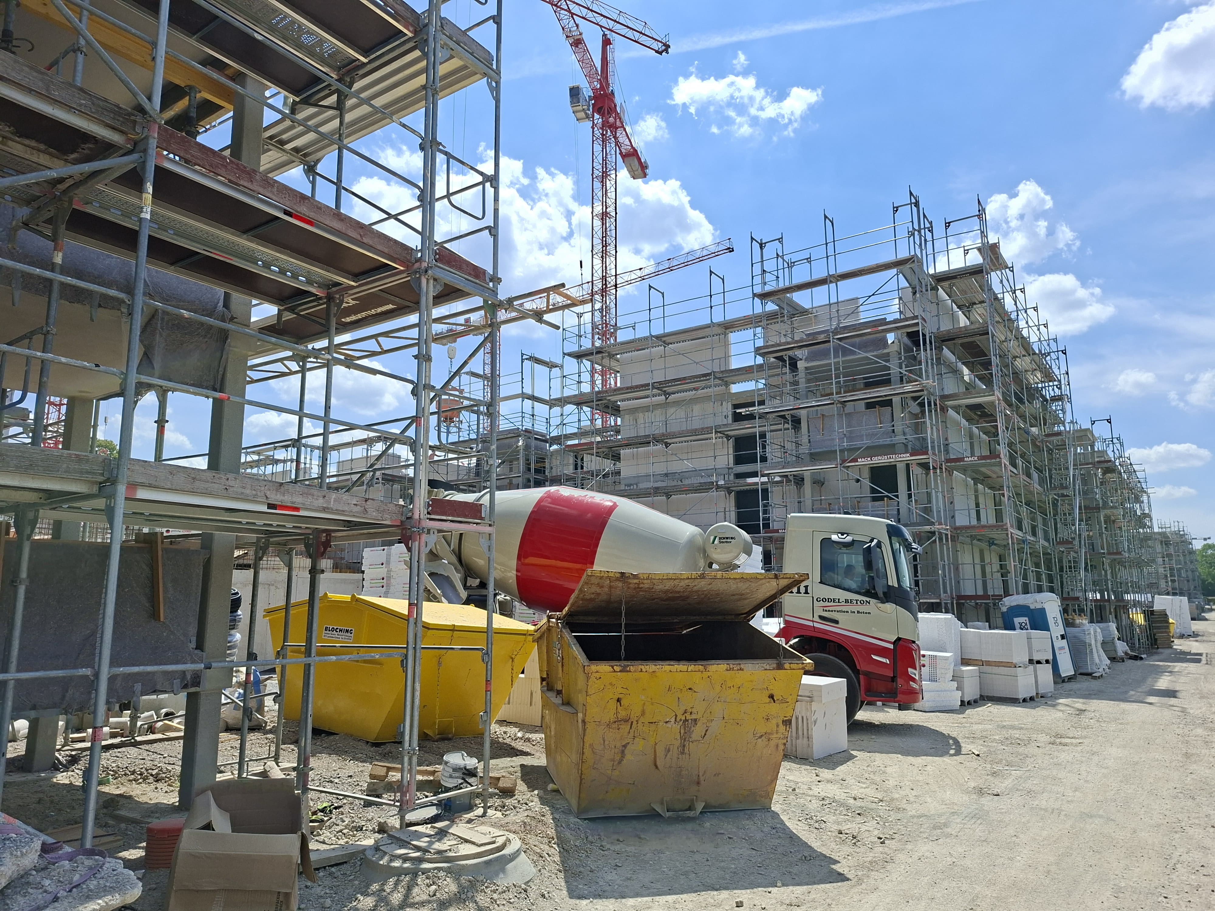 Container und ein Betonmischauto auf einer Baustelle